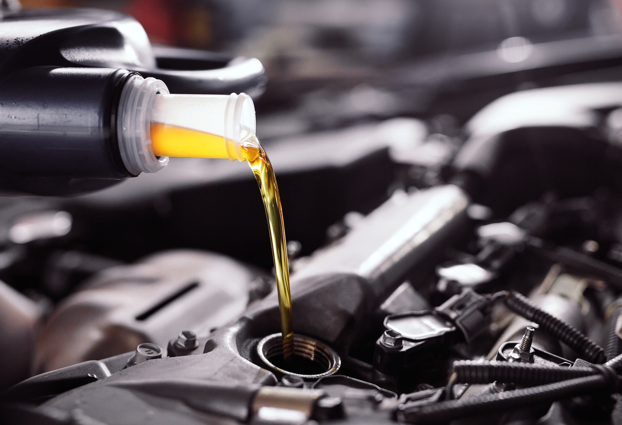 Motor oil pouring to car engine.